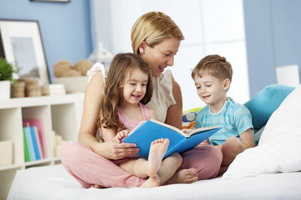 Mother reading with children at bedtime