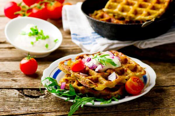 potato waffle with sour cream and green salad on a plate.style rustic .selective focus