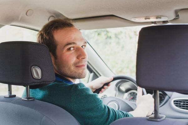 portrait of driver in the car or taxi, young caucasian man