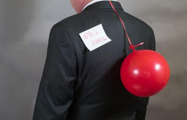 72939294 - fools day is businessman with a balloon behind his back
