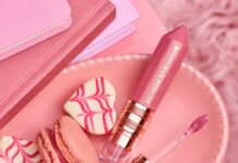 essence BOOK LOVERS CLUB – kosmetyki z książkowym wątkiem Kosmetyki essence BOOK LOVERS CLUB w różowych i burgundowych opakowaniach ułożone na otwartych notesach.